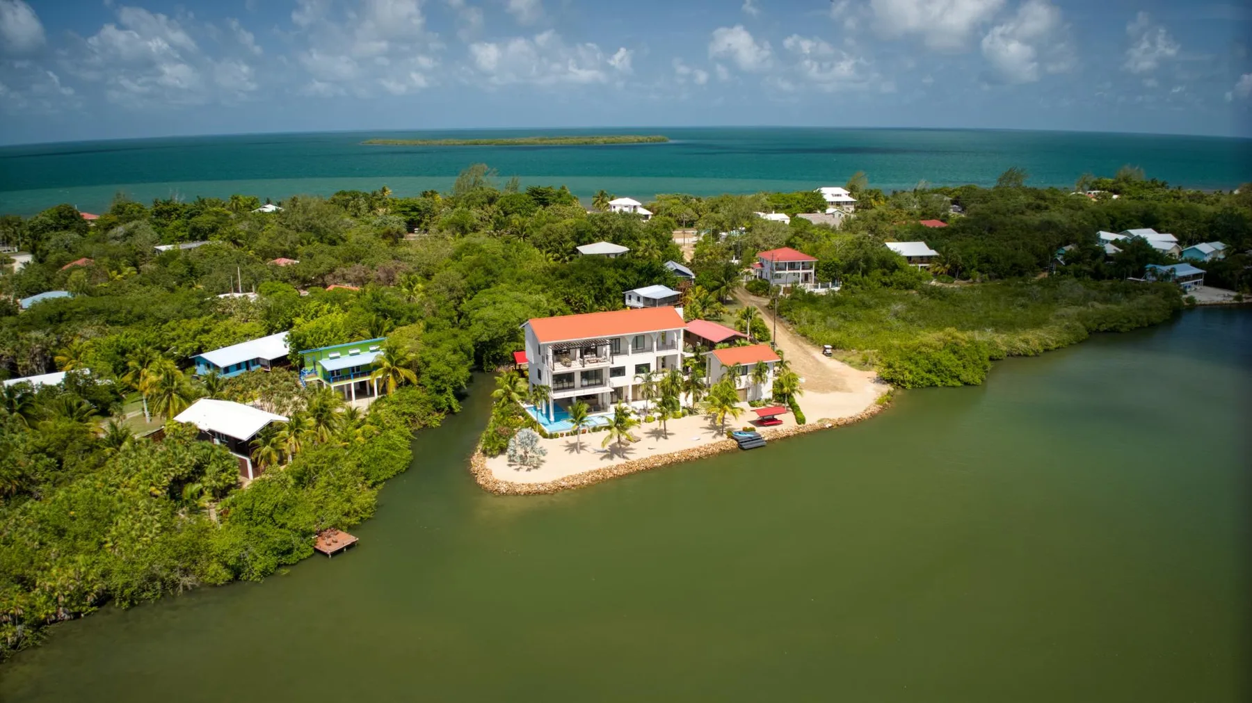 An aerial view of a coastal settlement, with a prominent building beside the water.