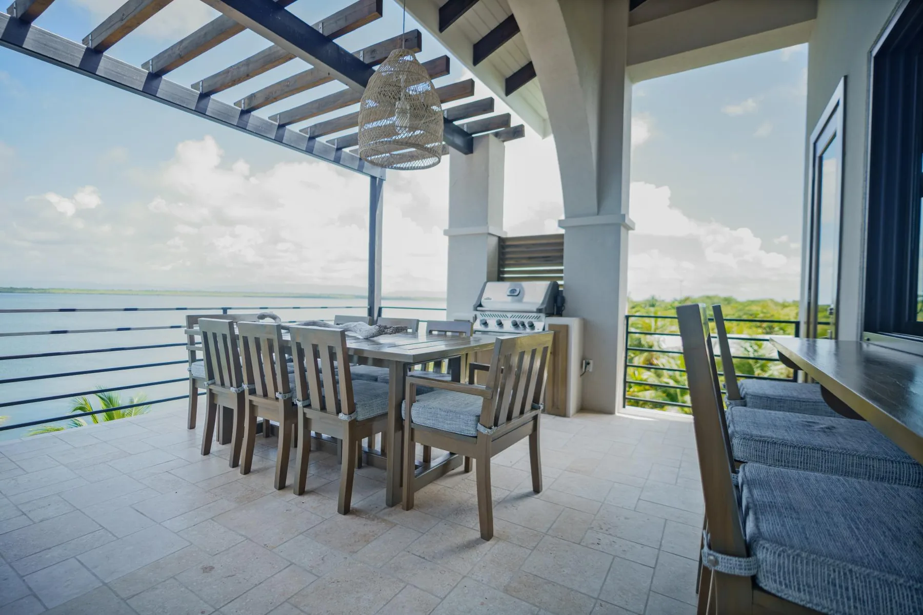 A covered outdoor dining area with a table and built-in grill.