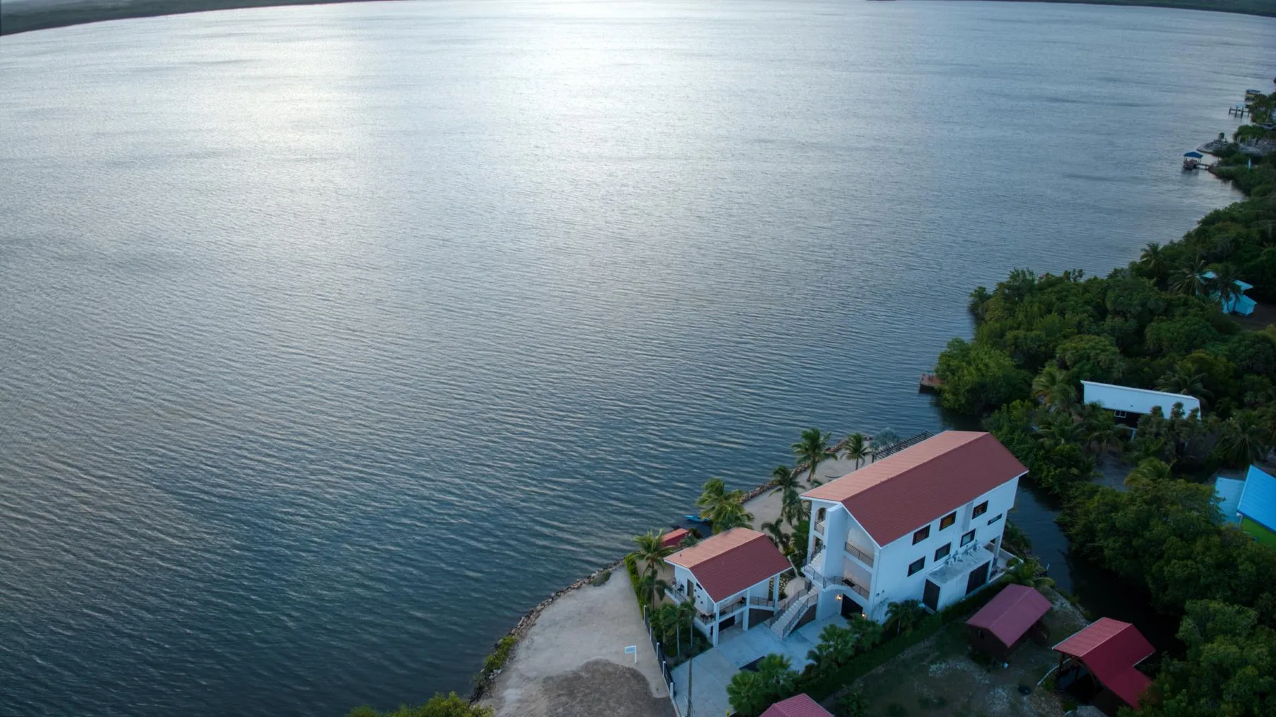Aerial view of waterfront buildings beside a broad body of water.