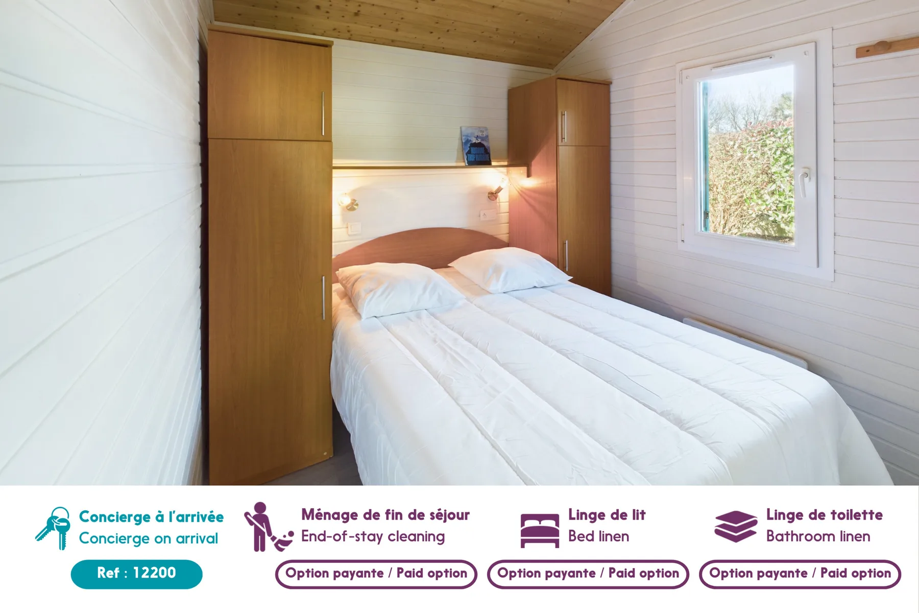 A bedroom with a double bed between wooden wardrobes and a window.