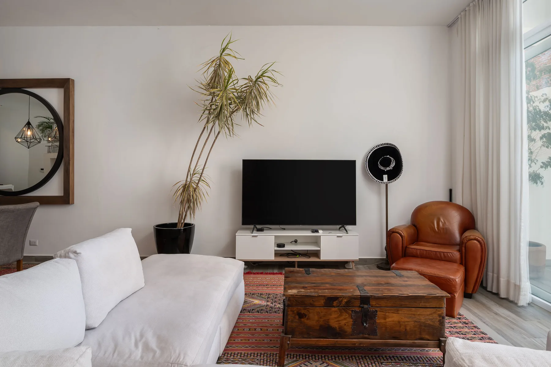 A living room with a television, seating, and a wooden coffee table.
