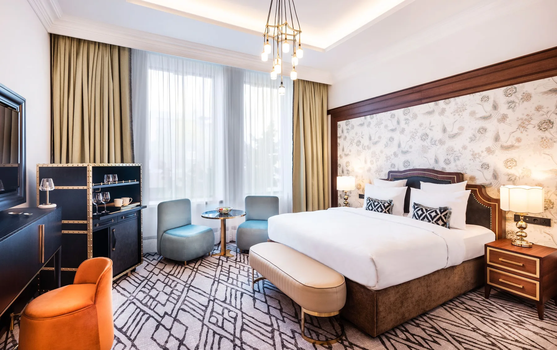 Espacio representativo del hotel: Un dormitorio de hotel con una cama amplia y asientos junto a la ventana.