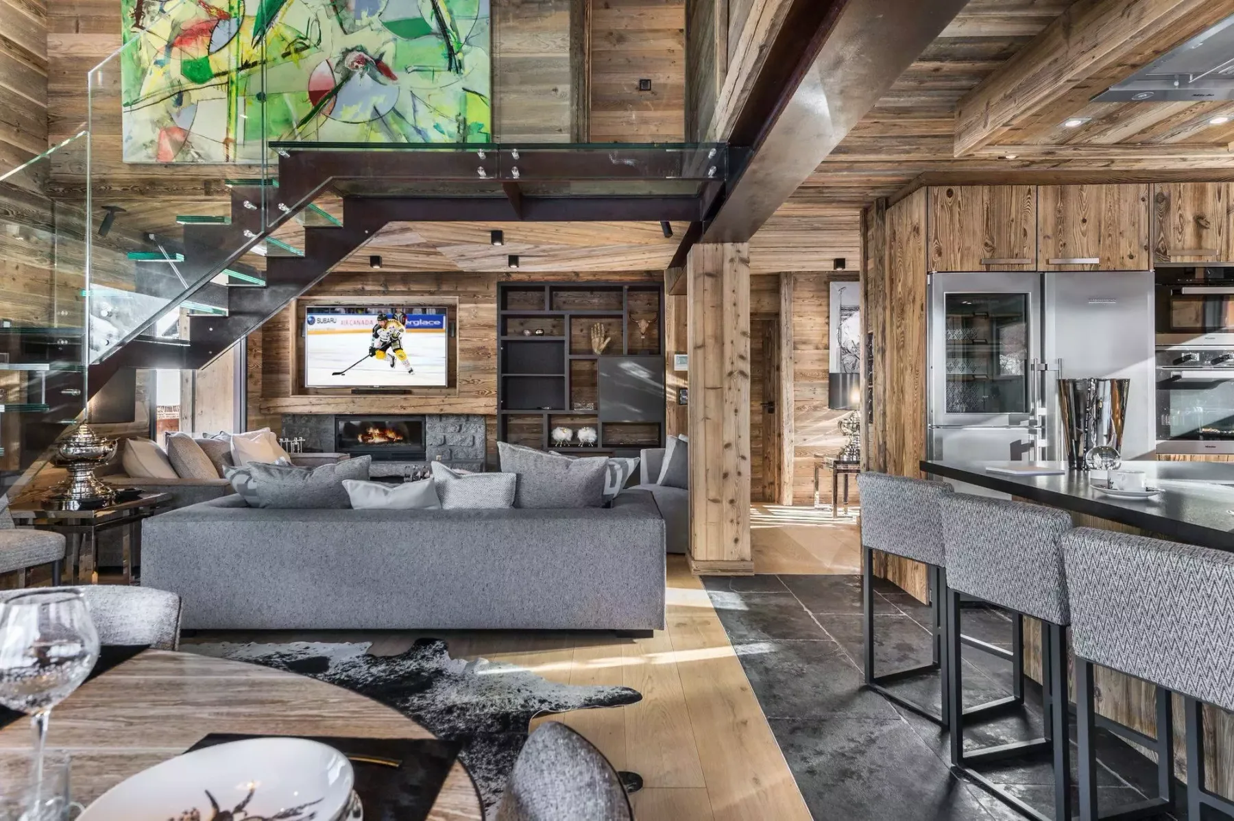 Una sala revestida de madera con una zona de asientos bajo una escalera.