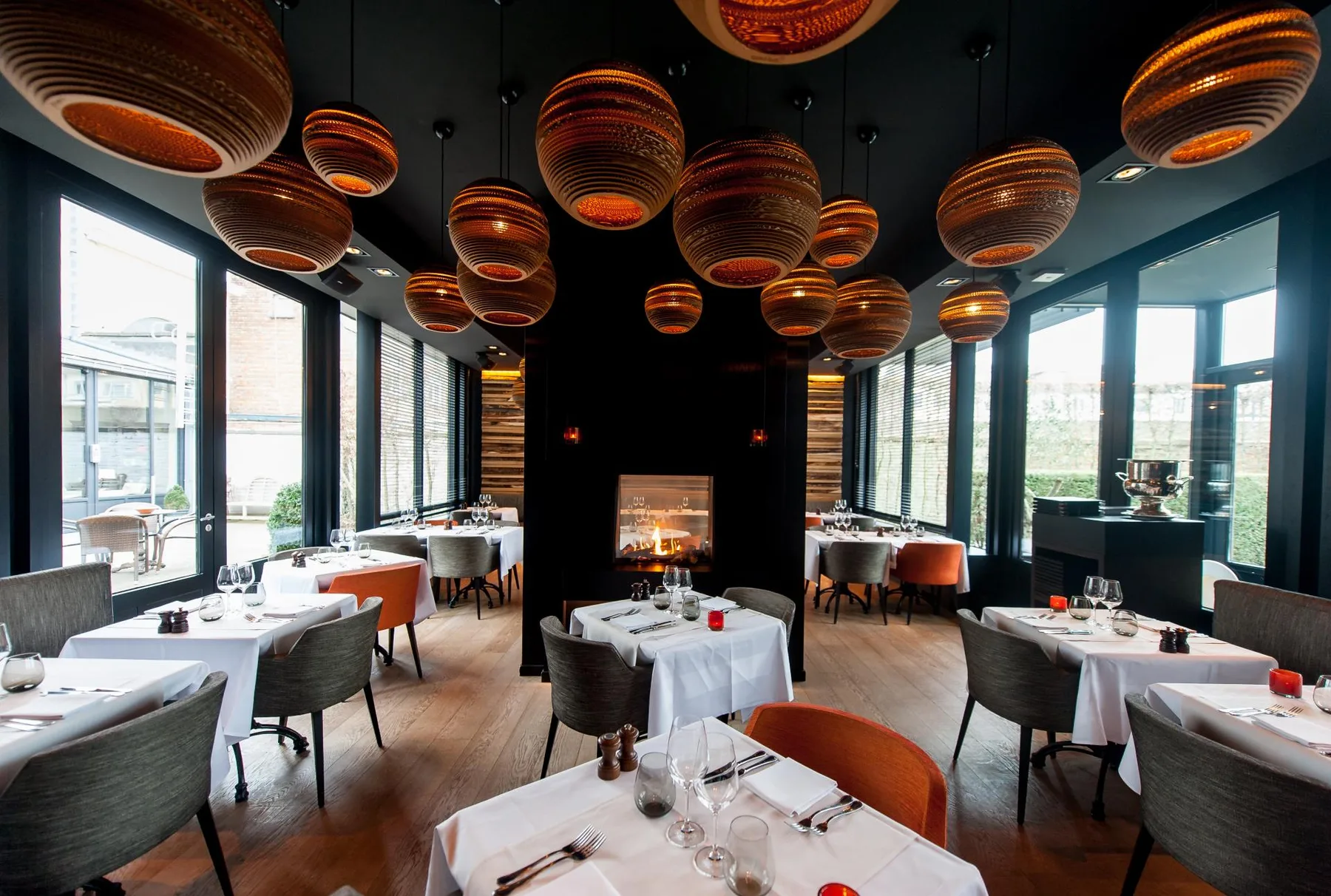 Espacio representativo del hotel: Un comedor con mesas y lámparas colgantes junto a grandes ventanales.