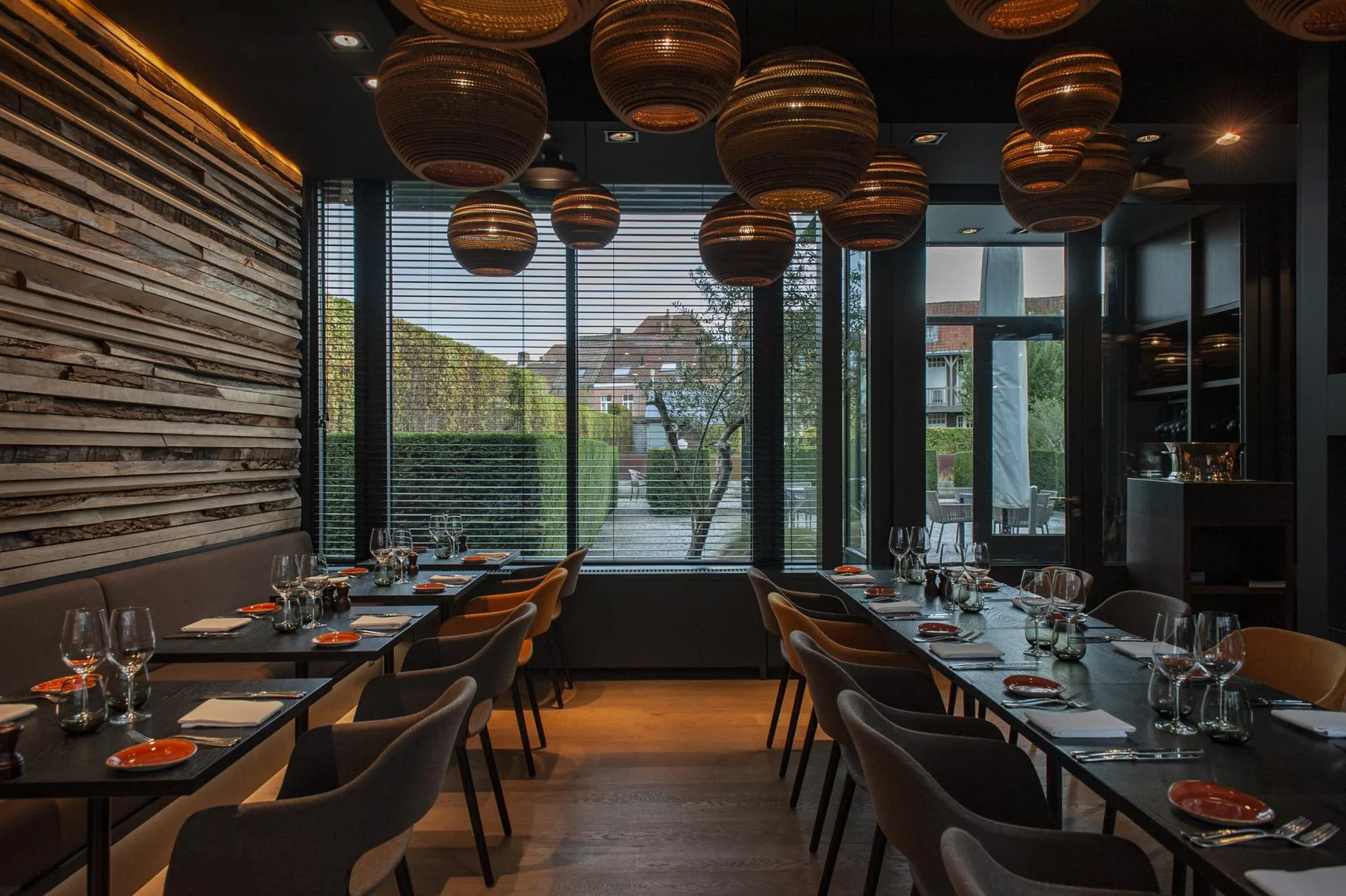 Espacio representativo del hotel: Un comedor de restaurante moderno con mesas preparadas junto a grandes ventanales.