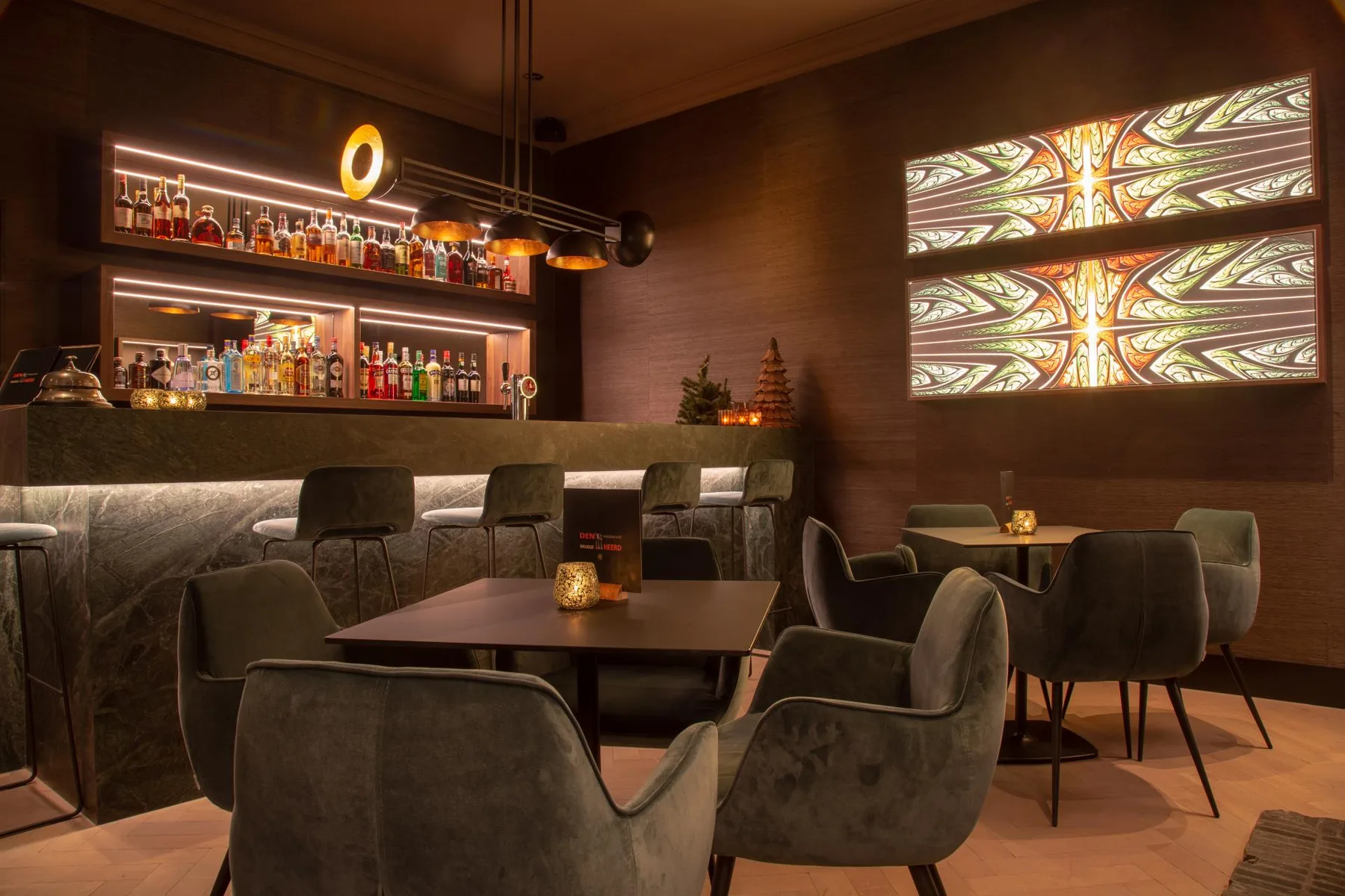Espacio representativo del hotel: Un bar y salón con poca luz cuenta con una barra, mesas y asientos.