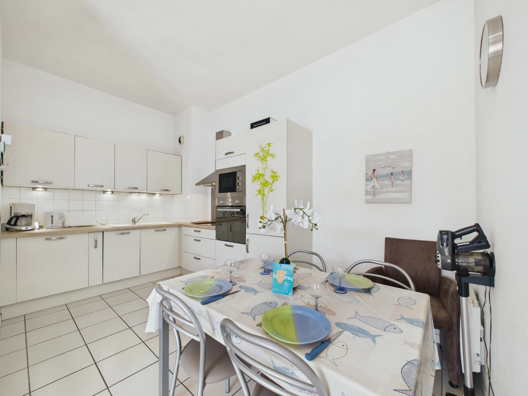 A bright kitchen and dining area with a table set with dishes.