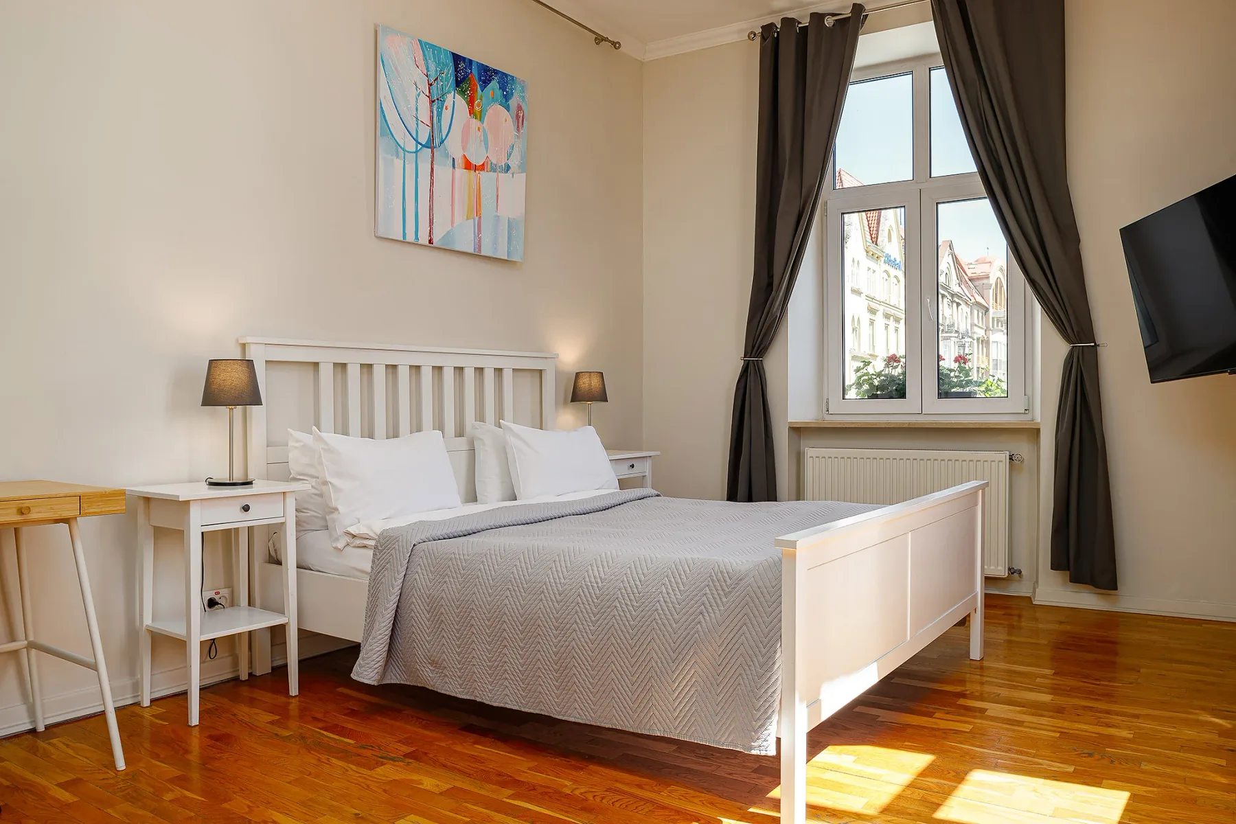 Representative hotel space: A bedroom with a bed beside a large window and dark curtains.