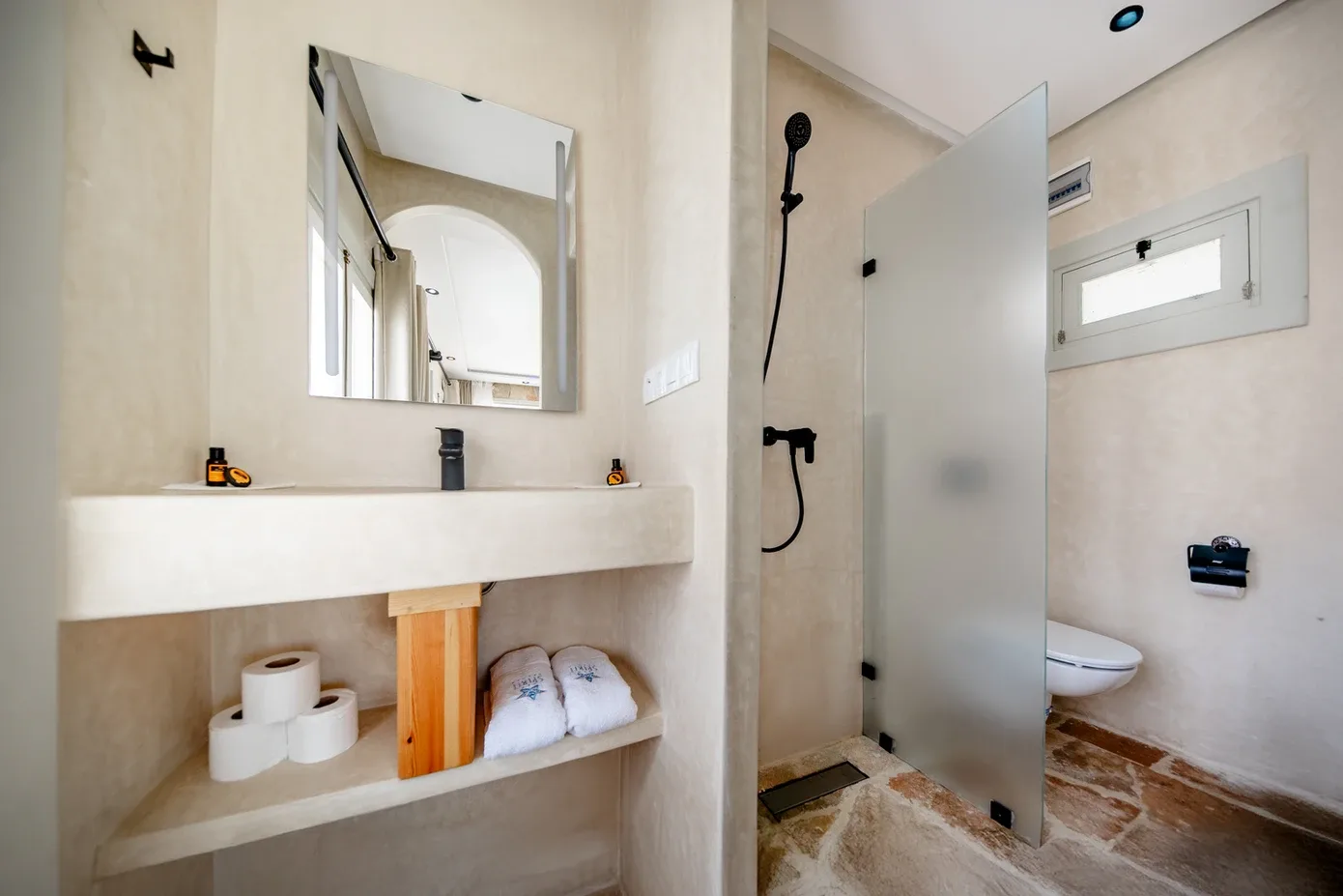 Representative hotel space: A bathroom with a sink area, mirror, and shower.
