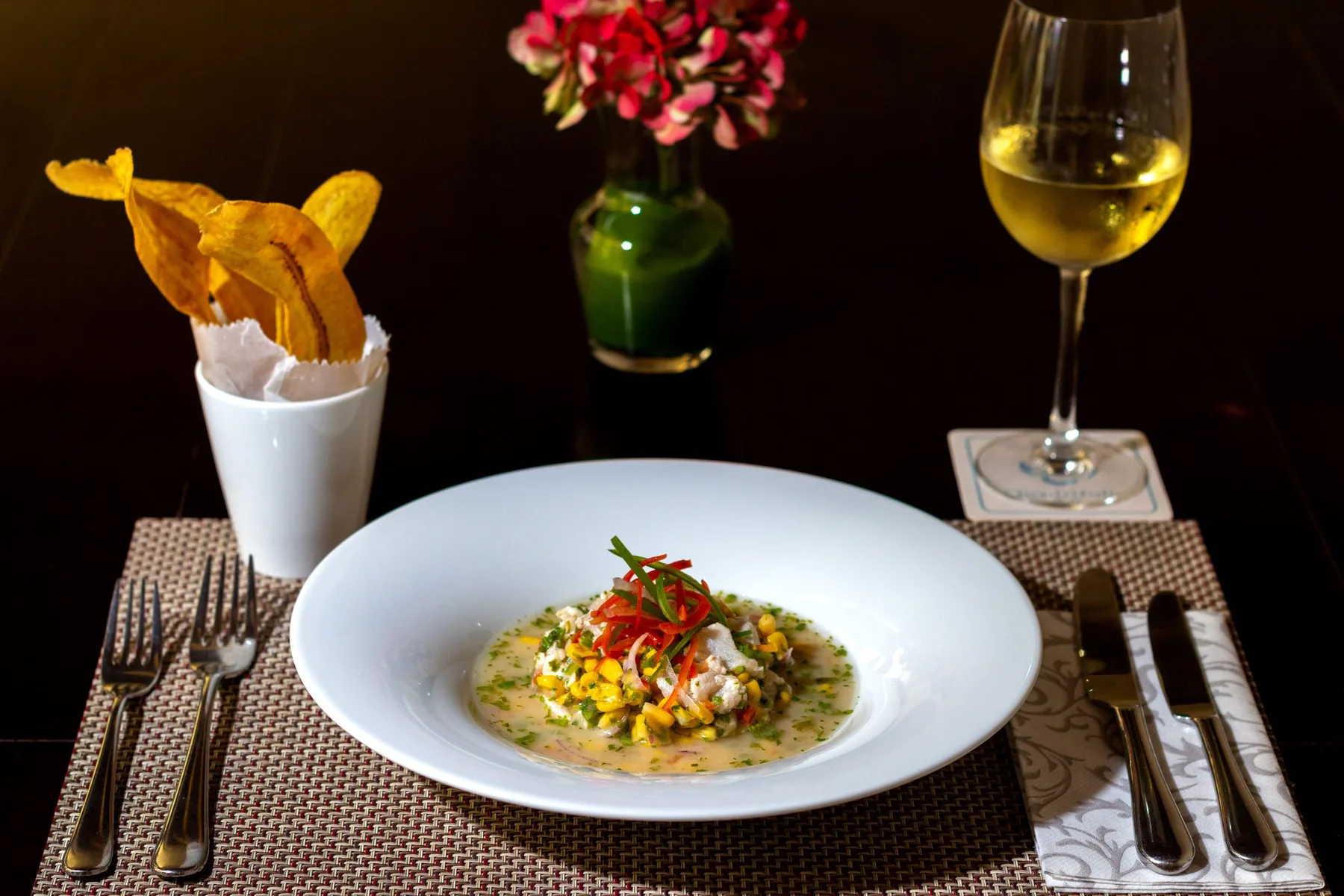 Representative hotel space: A plated meal sits on a dining table beside a glass of wine.
