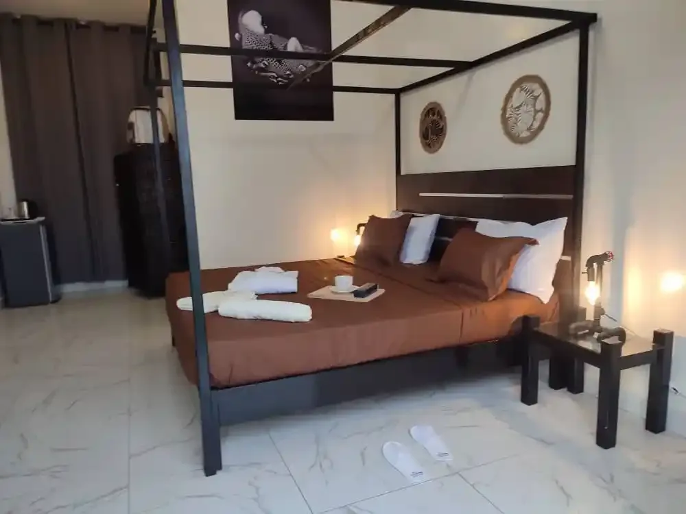 Representative hotel space: A bedroom with a canopy bed, folded towels, and bedside tables.