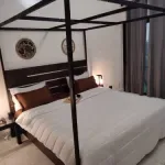 Representative hotel space: A bedroom with a canopy bed and curtains along the window.