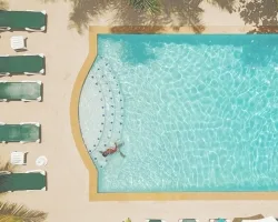 Espacio representativo del hotel: Una piscina al aire libre con escalones curvos en un lado.