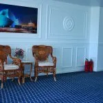Espacio representativo del hotel: Una zona de estar tiene sillas de madera junto a una pared con paneles.