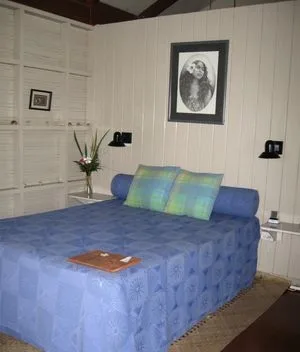 Espacio representativo del hotel: Un dormitorio con una colcha azul y un retrato enmarcado en la pared.