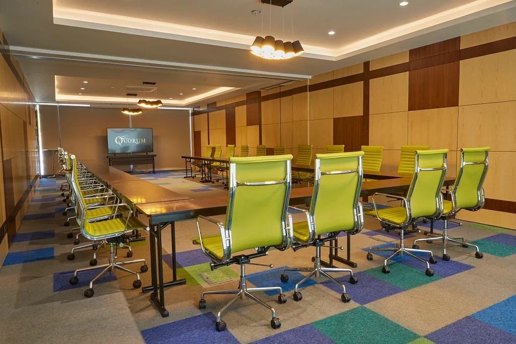 Representative hotel space: A conference room with long tables and rows of green chairs.