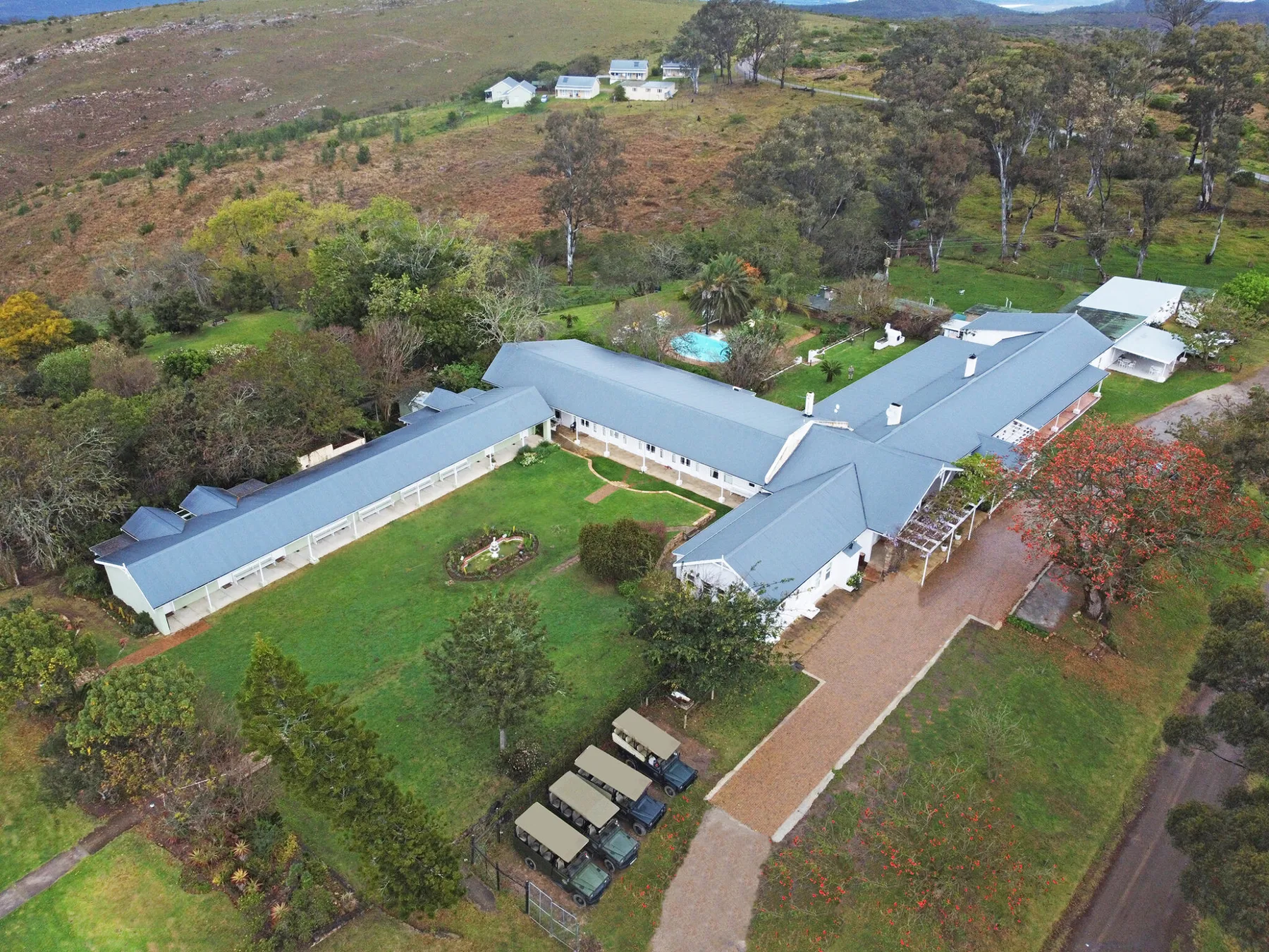 Representative hotel space: An aerial view of a sprawling hotel complex surrounded by green grounds and wooded hills.
