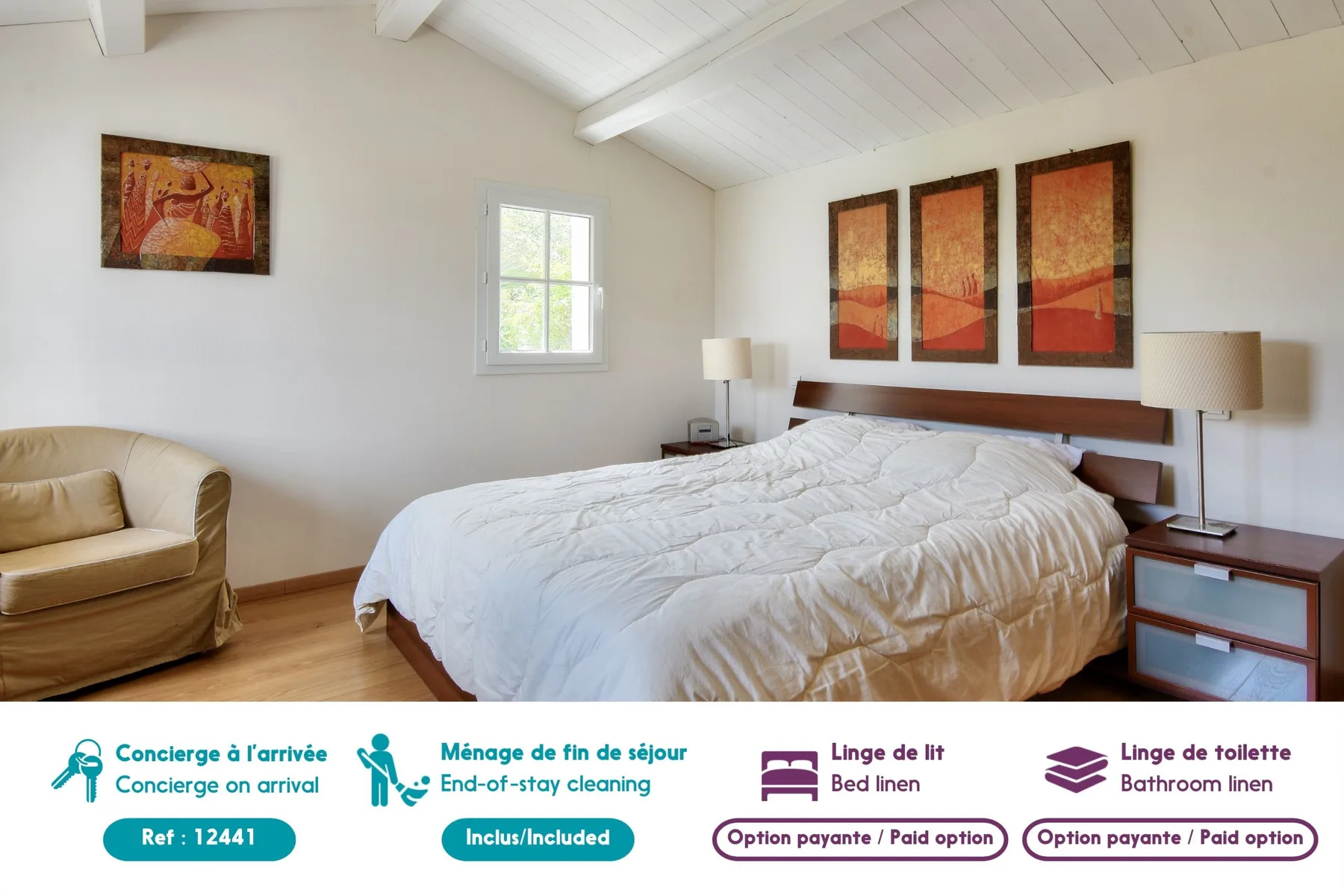 A bright bedroom with a large bed, bedside tables, and wall art.