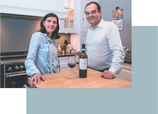 Espacio representativo del hotel: Dos personas están junto a una encimera de cocina con una botella y copas.