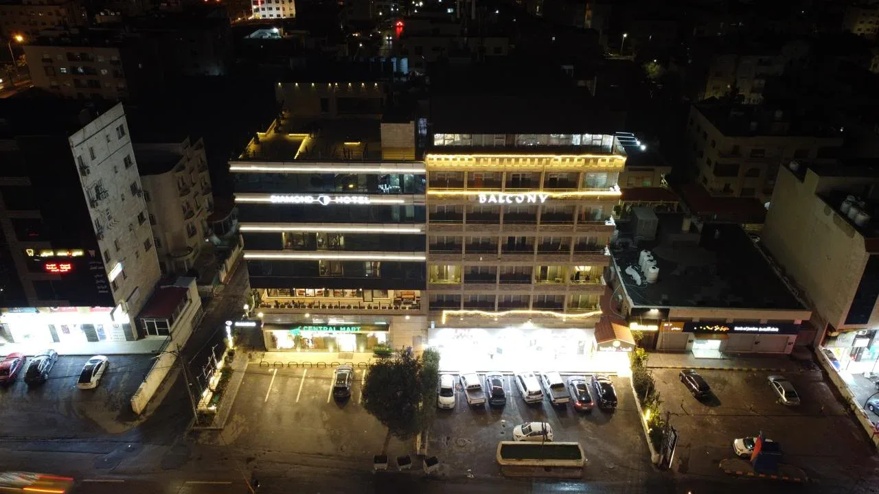 Espacio representativo del hotel: Un edificio de hotel y su estacionamiento iluminado por la noche.