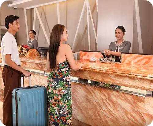 Representative hotel space: Hotel reception area with guests speaking to staff at the counter.