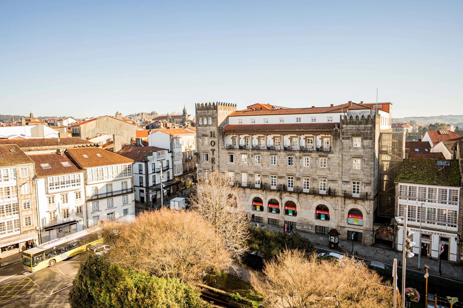 Espacio representativo del hotel: Una plaza urbana rodeada de edificios históricos y árboles frondosos.