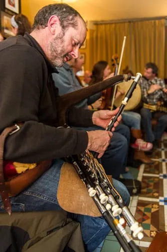 Representative hotel space: A seated musician adjusts a woodwind instrument in a warmly lit room.