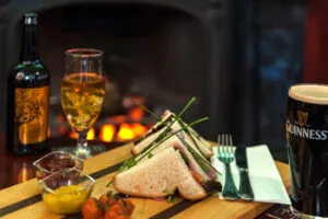 Representative hotel space: A prepared meal with bread, vegetables, wine, and a pint of stout.