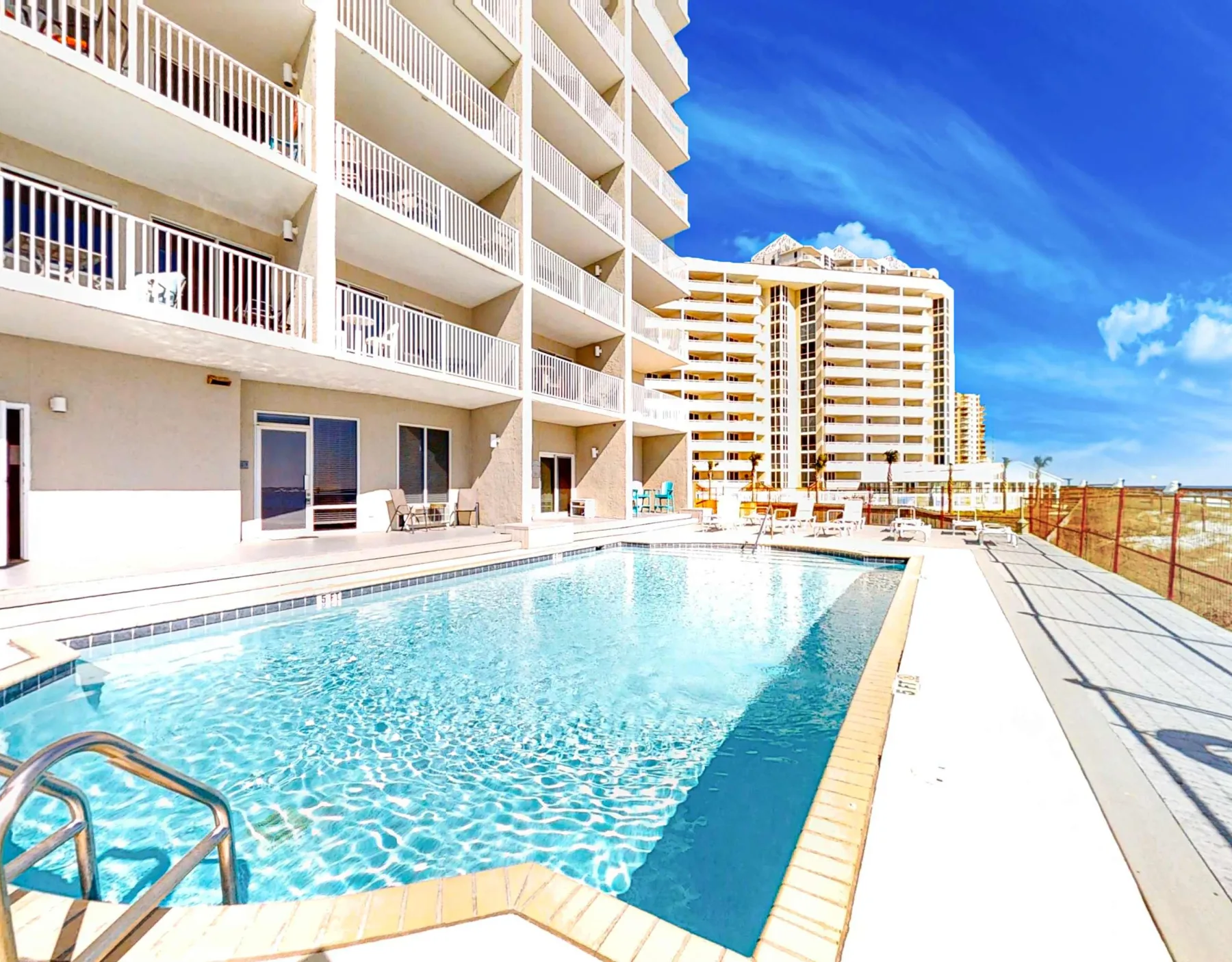 Shared amenity: An outdoor swimming pool beside a multi-story building.