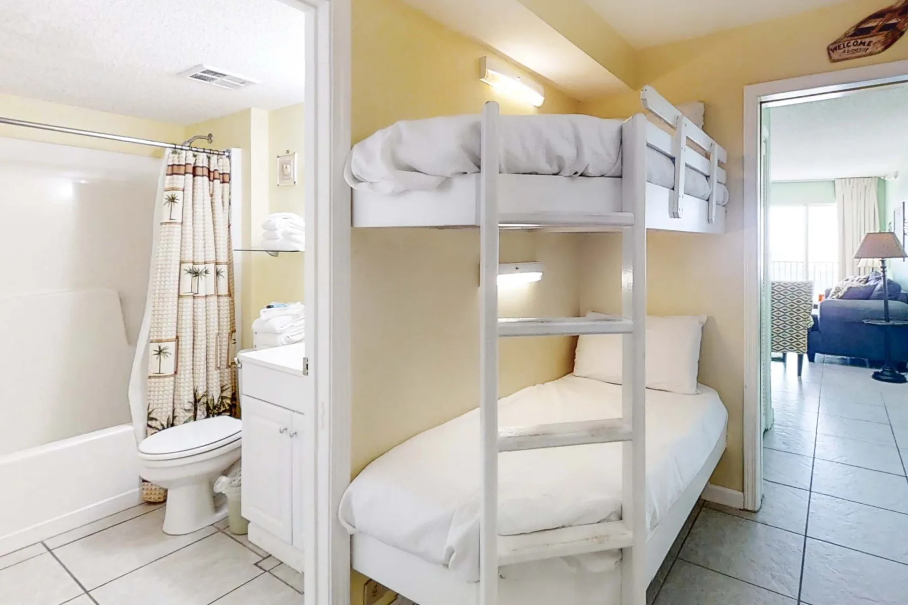 A bedroom with bunk beds, a single bed, and an adjoining bathroom.