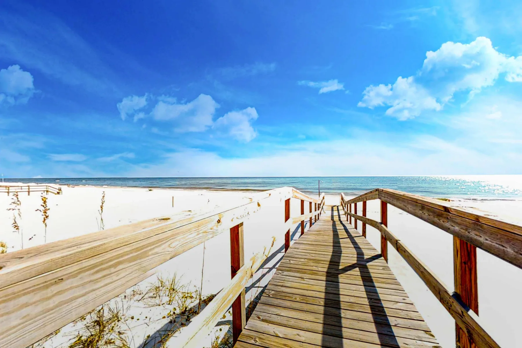 Shared amenity: A wooden boardwalk crosses the sandy beach toward the ocean.