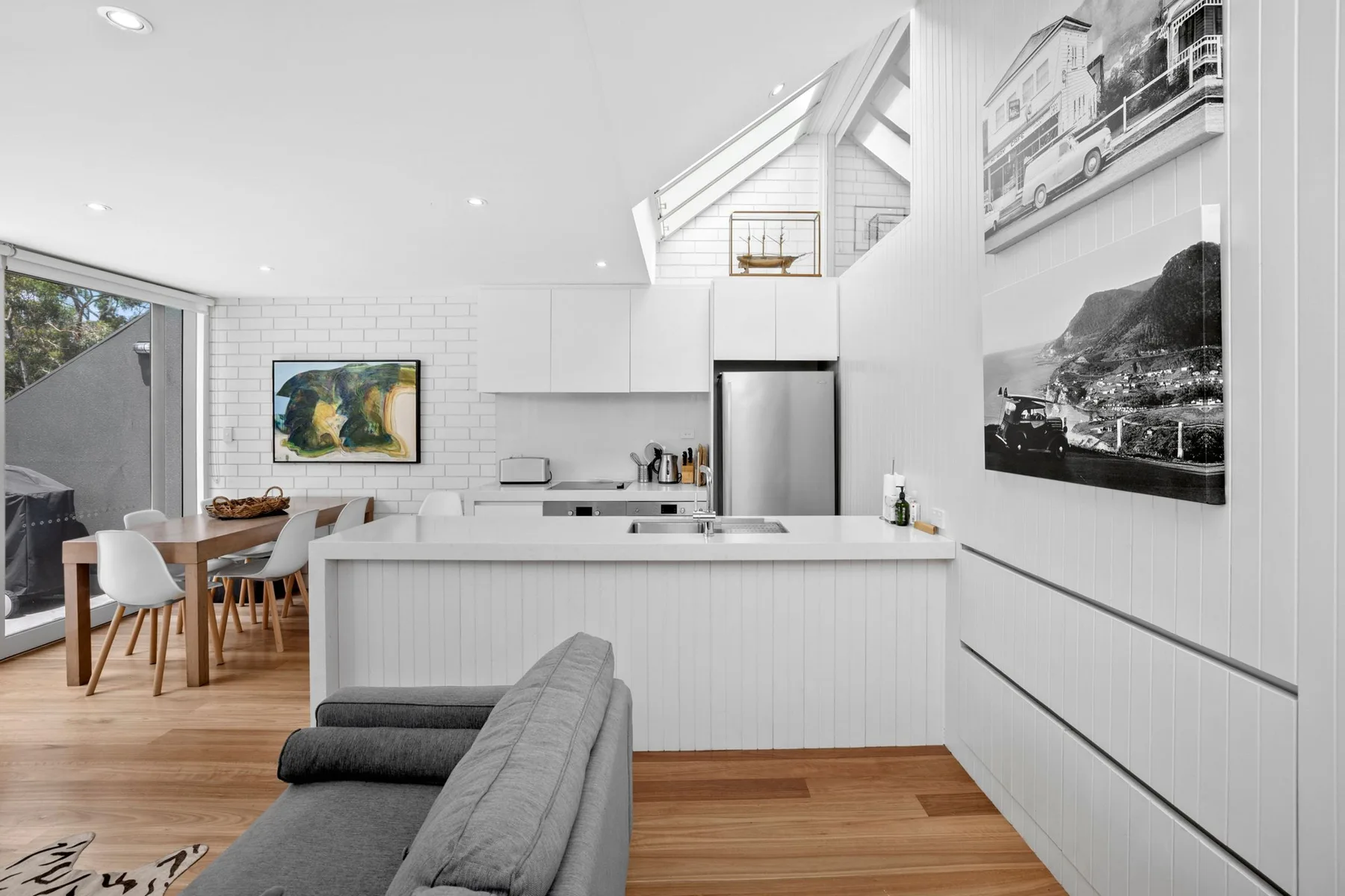 A bright open-plan kitchen and dining area with a counter and seating.