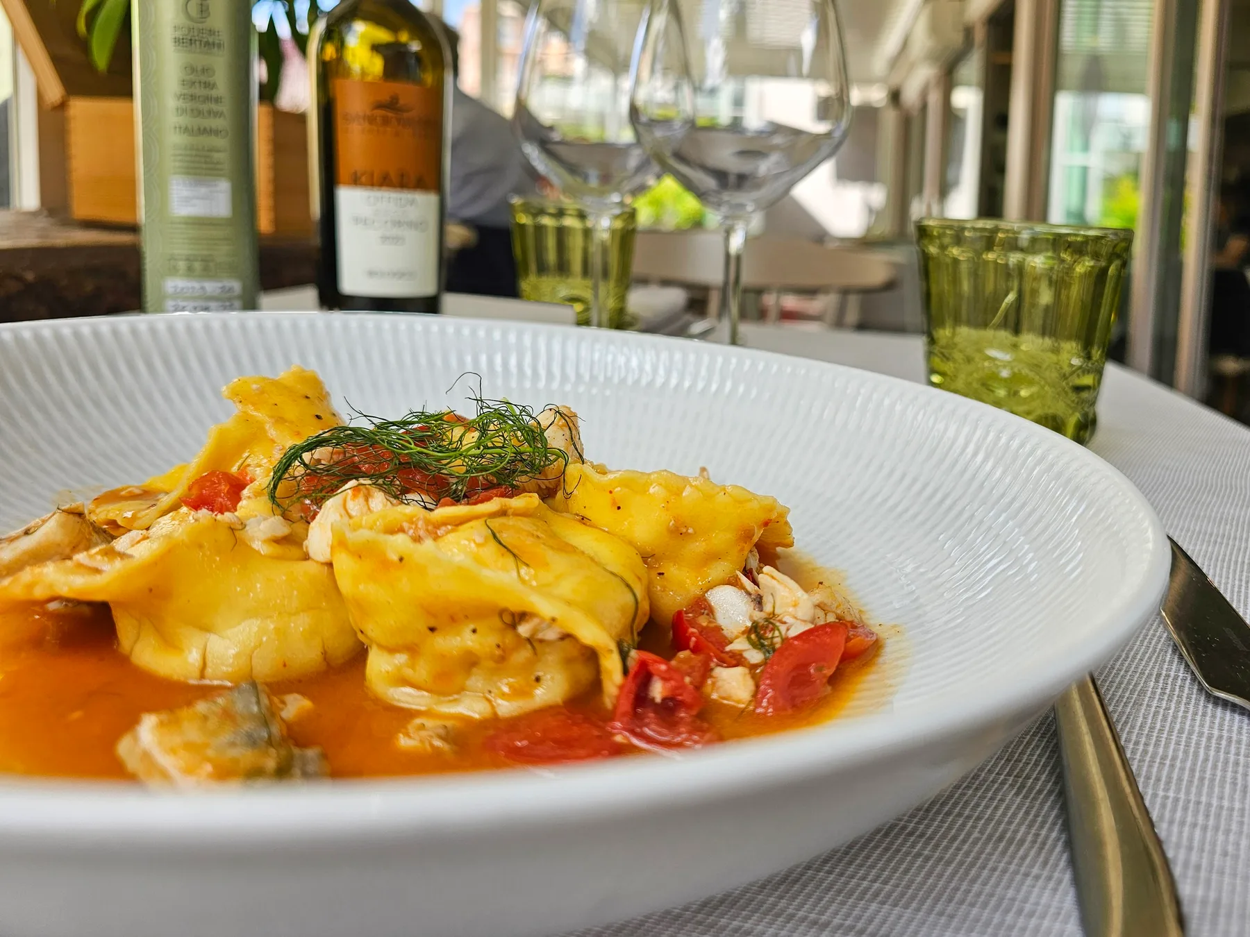 Representative hotel space: A plated pasta dish sits on a restaurant table with wine glasses and bottles behind it.