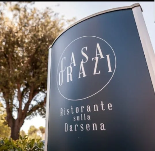 Representative hotel space: An outdoor restaurant sign stands beside a leafy tree.