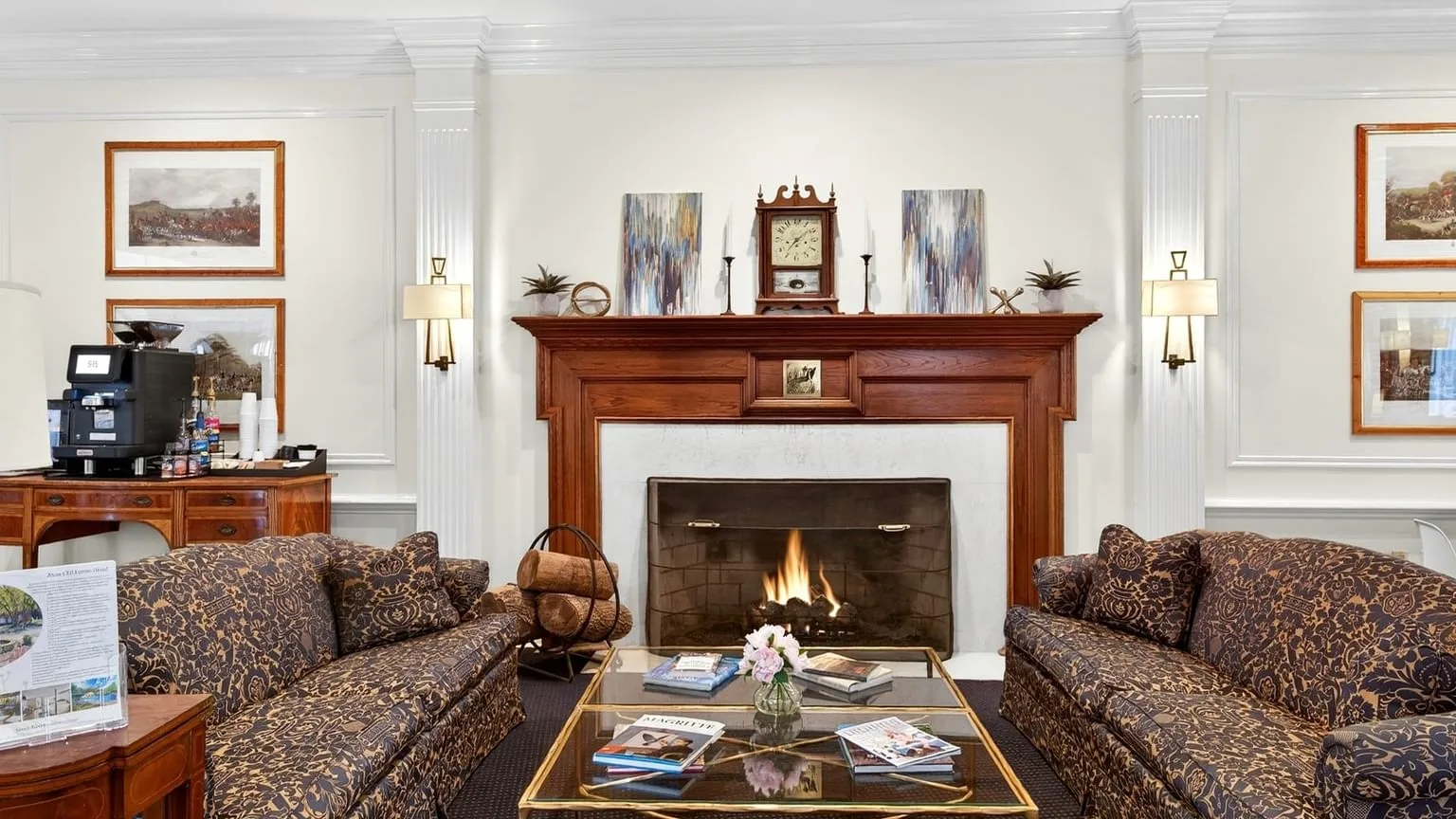Espacio representativo del hotel: Una sala formal con asientos estampados dispuestos alrededor de una chimenea.