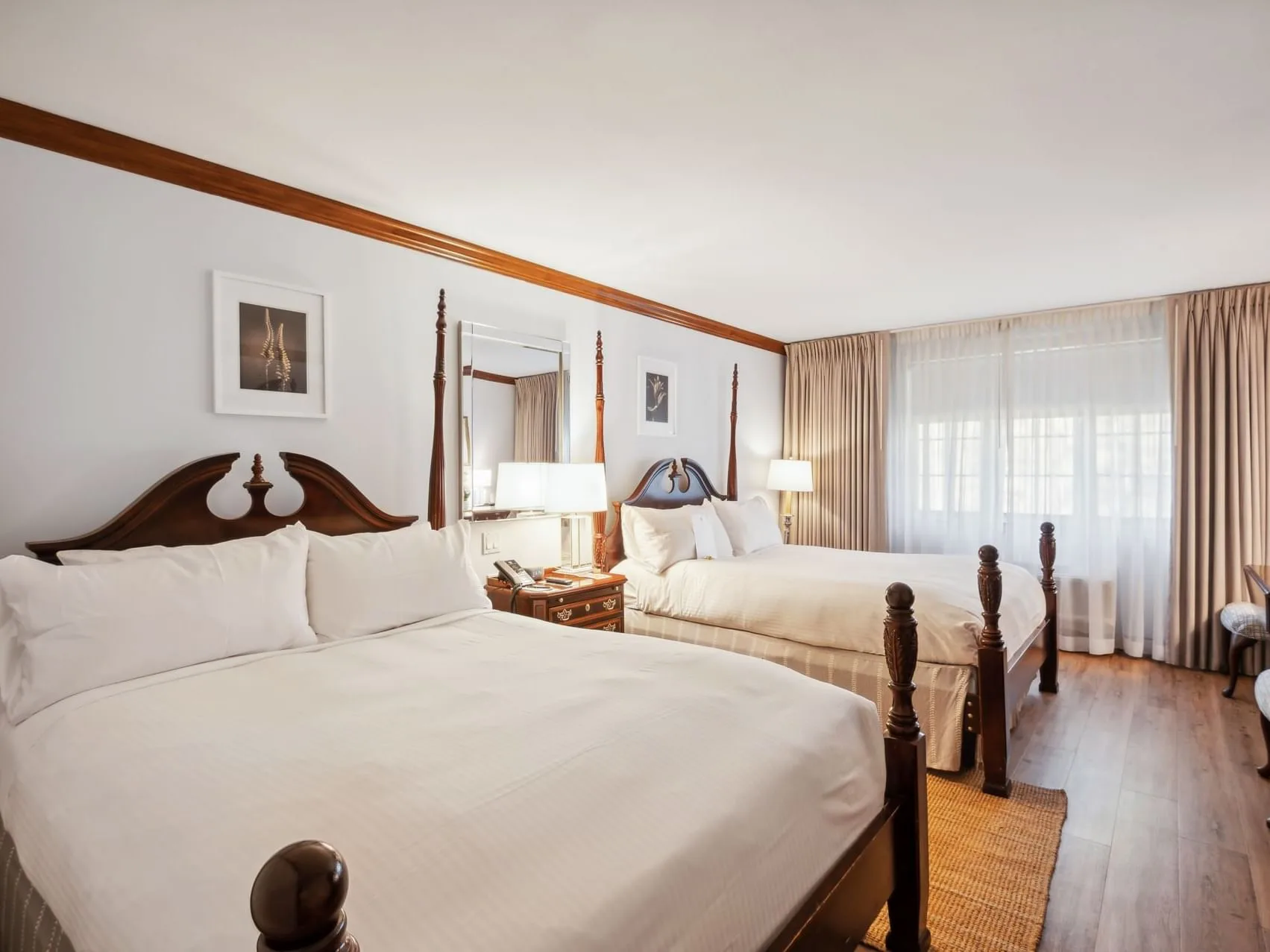 Espacio representativo del hotel: Un dormitorio con dos camas, mesitas de noche y una gran ventana con cortinas.