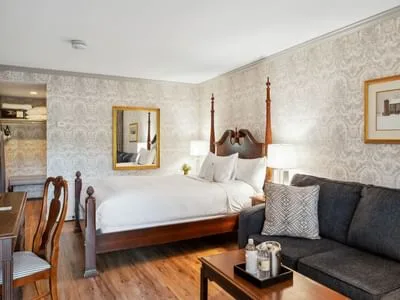 Espacio representativo del hotel: Un dormitorio con una cama blanca y un sofá oscuro a su lado.