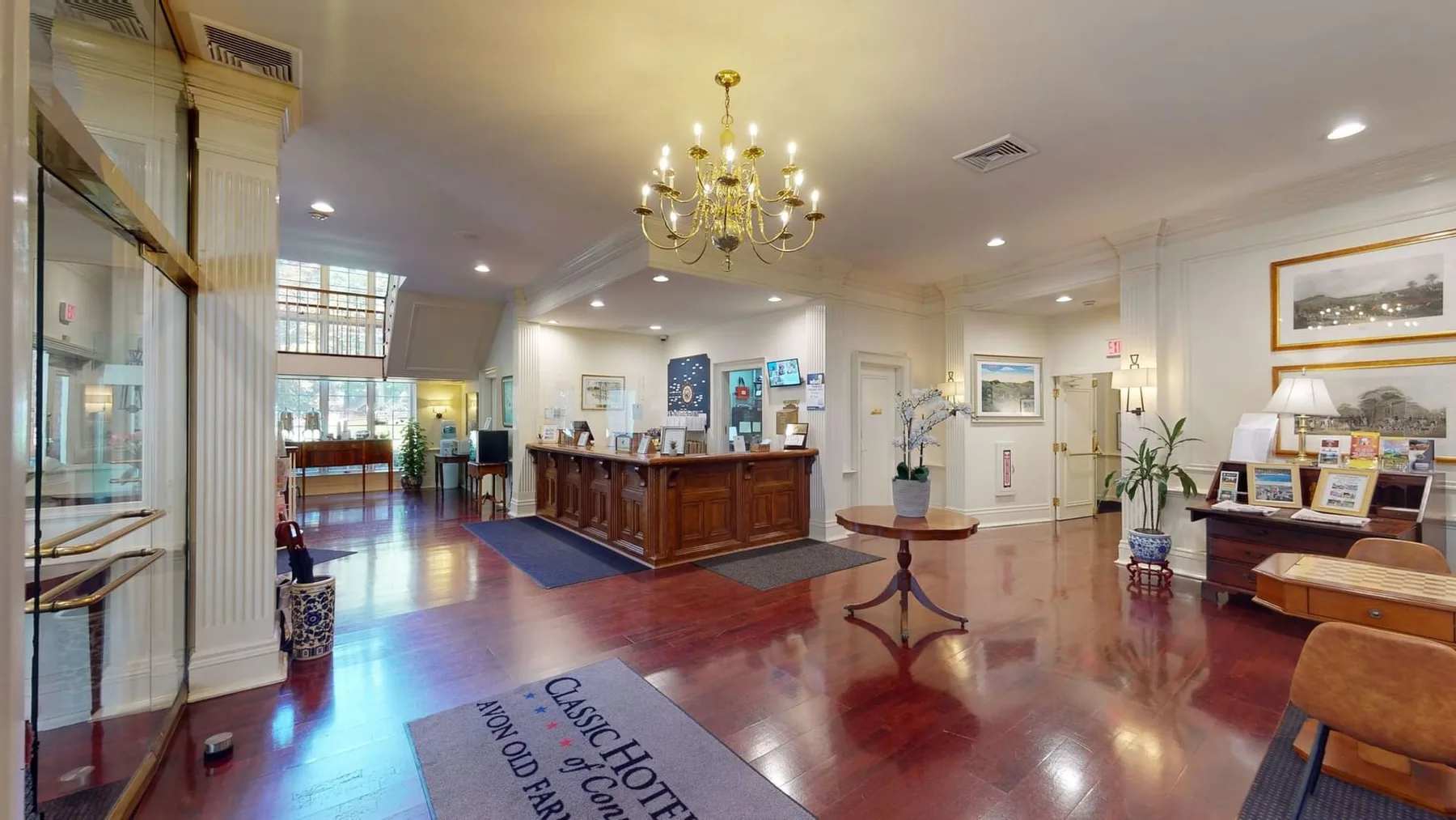 Espacio representativo del hotel: Vestíbulo de hotel con mostrador de recepción de madera y zona de estar.