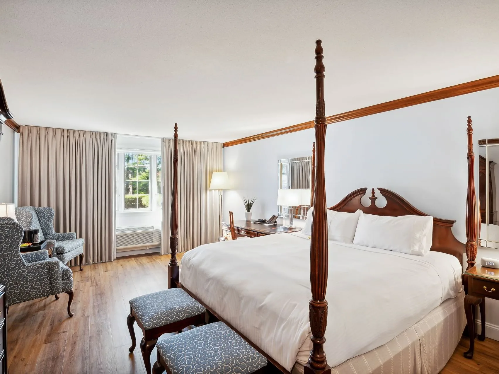 Espacio representativo del hotel: Dormitorio con cama con dosel, asientos tapizados y ventanas altas con cortinas.
