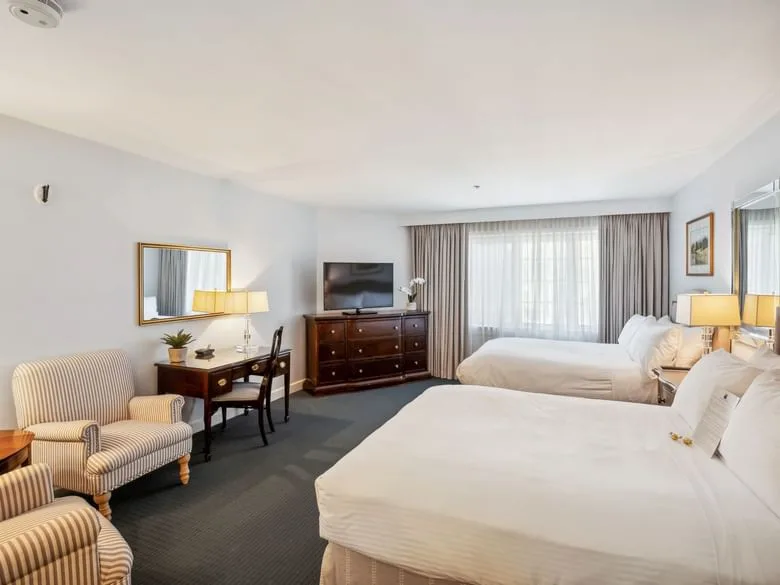 Espacio representativo del hotel: Una habitación de hotel con dos camas, un televisor y un escritorio.