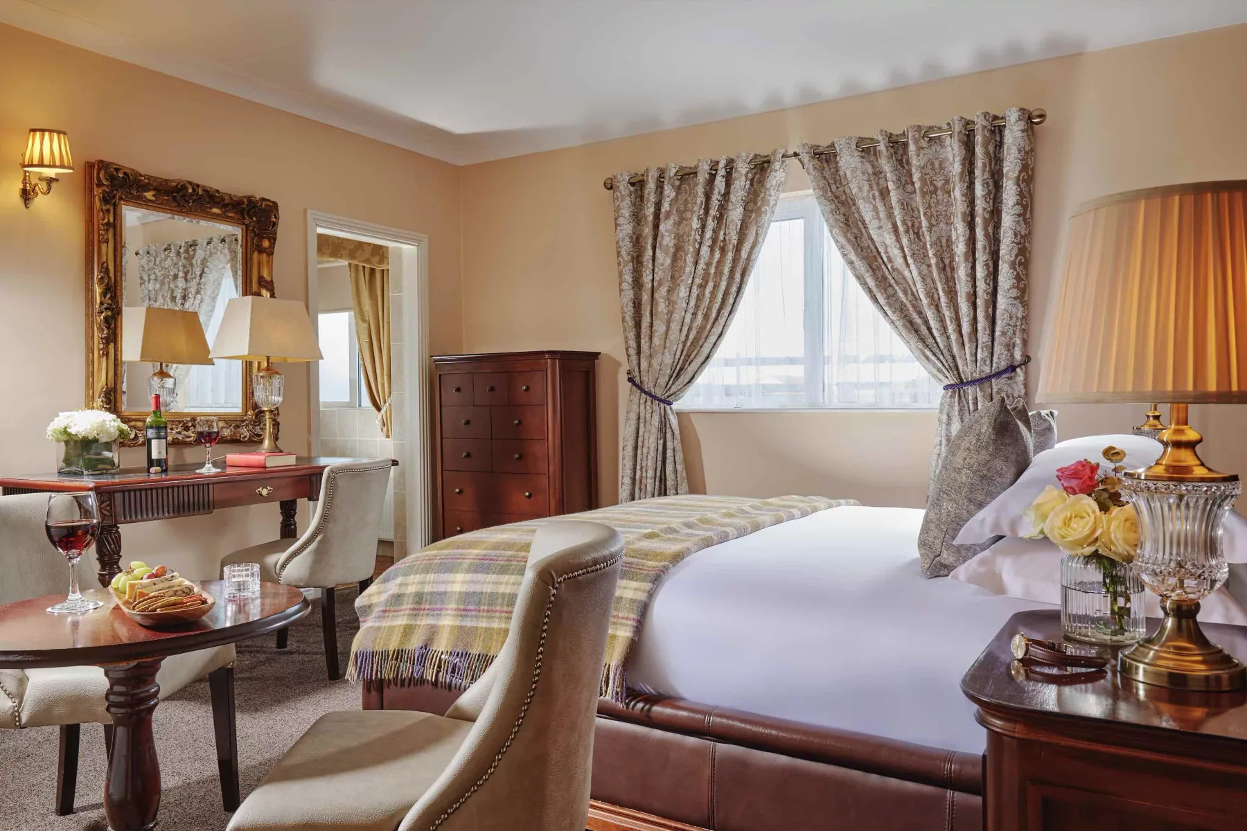 Representative hotel space: A bedroom with a bed, seating, and a window framed by patterned curtains.