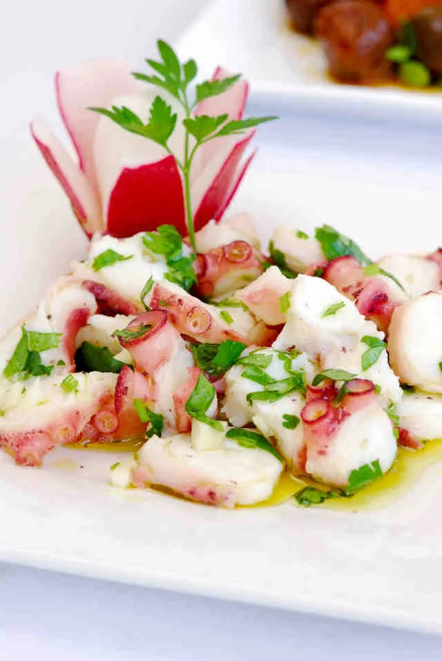 Representative hotel space: A plated seafood dish is garnished with herbs and thinly sliced vegetables.