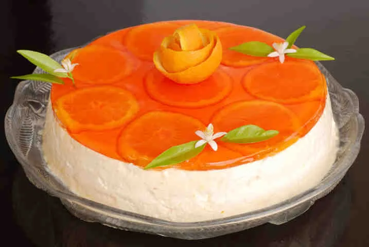 Representative hotel space: A round cream cake is topped with orange slices and small white flowers.
