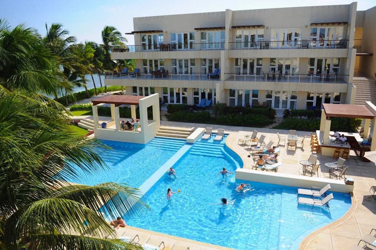 Espacio representativo del hotel: Una piscina de hotel está frente a un edificio de varios pisos con balcones.