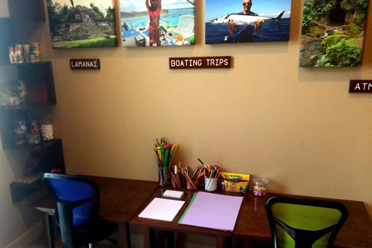 Espacio representativo del hotel: Un pequeño mostrador informativo con bolígrafos de colores y fotos enmarcadas en la pared.