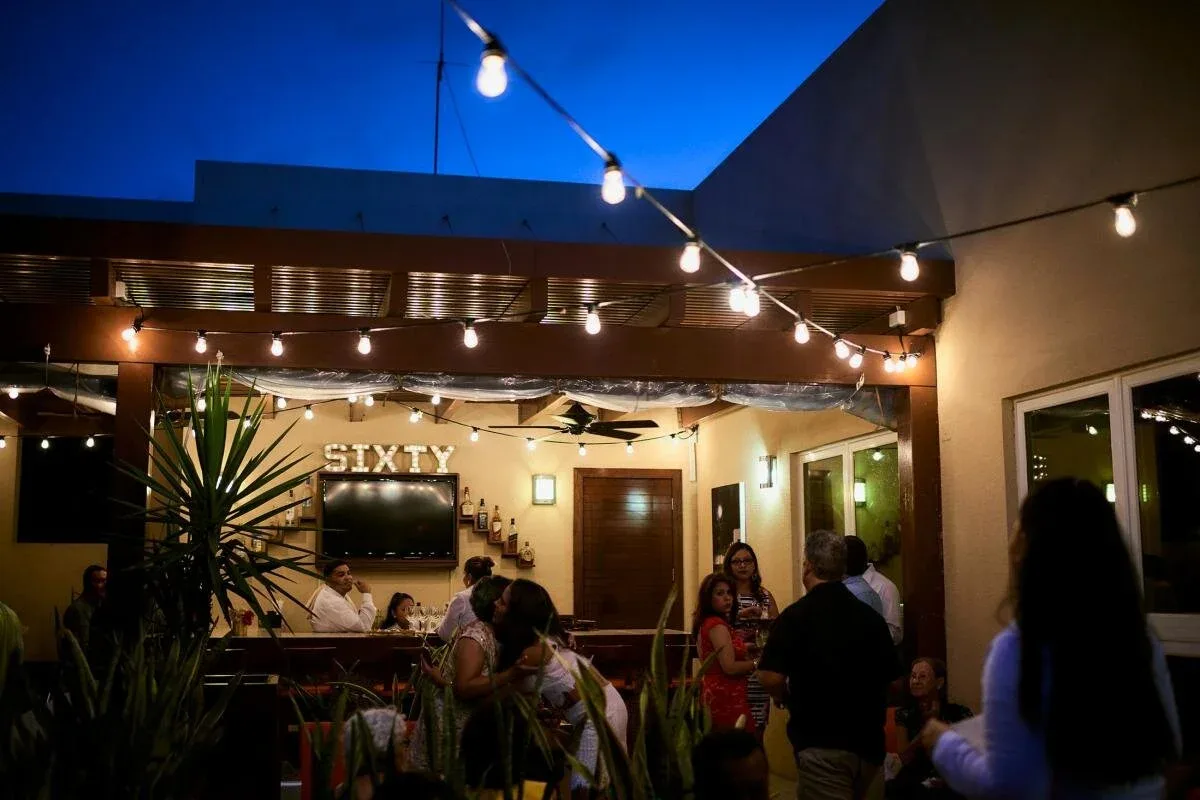 Espacio representativo del hotel: Un patio de restaurante al aire libre con comensales bajo luces de guirnalda.