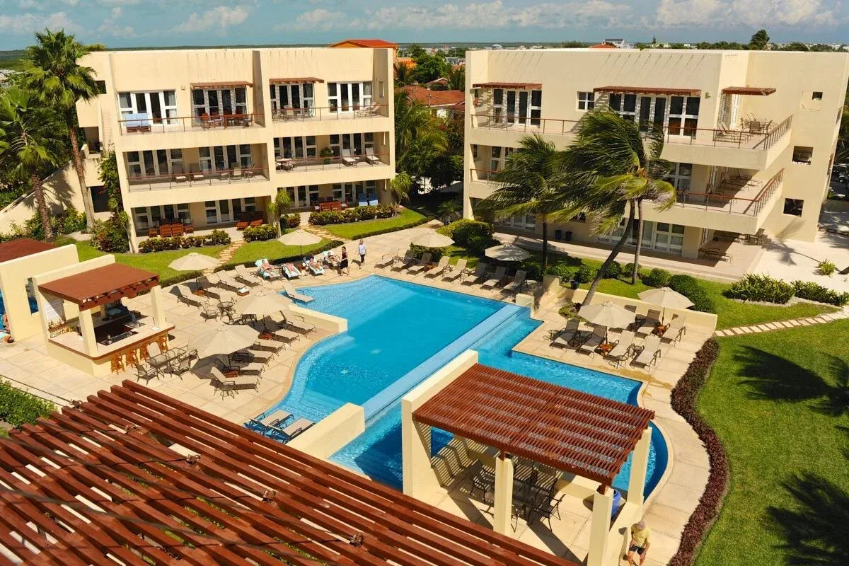 Espacio representativo del hotel: Vista aérea de una piscina entre dos edificios y jardines.
