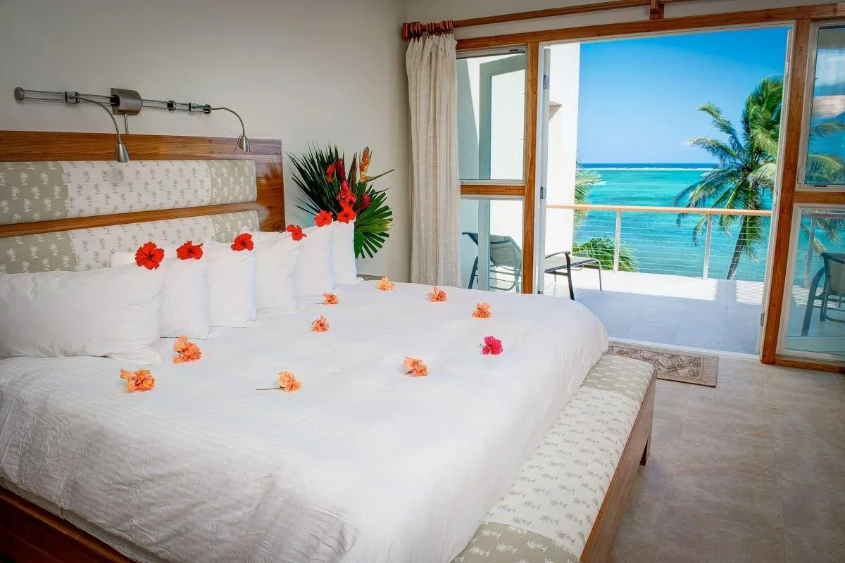 Espacio representativo del hotel: Un dormitorio con una cama frente a un balcón y vistas al mar.
