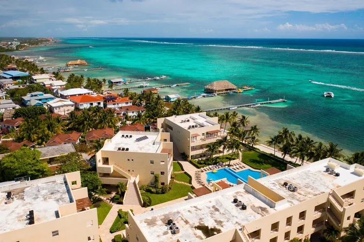 Espacio representativo del hotel: Vista aérea de edificios costeros junto al agua turquesa y una piscina.
