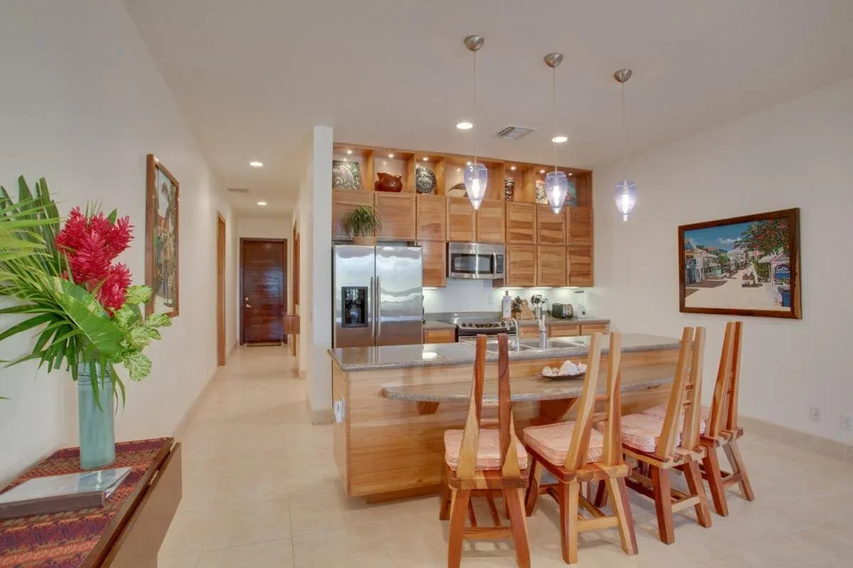 Espacio representativo del hotel: Una cocina abierta y zona de comedor con gabinetes de madera y una mesa.
